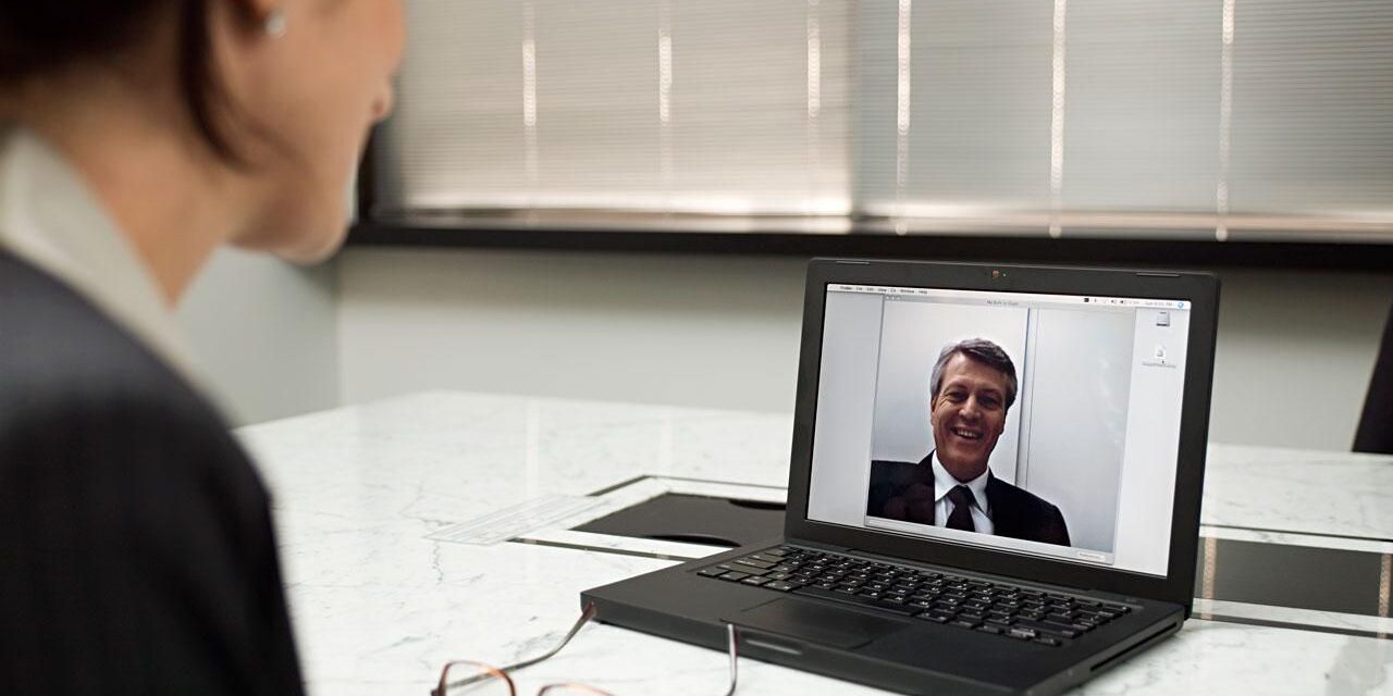Business woman conducting remote interview on laptop